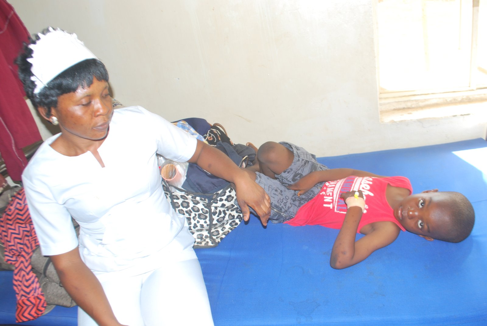 Nigerian nurse attending to patient in hospital ward in Nigeria